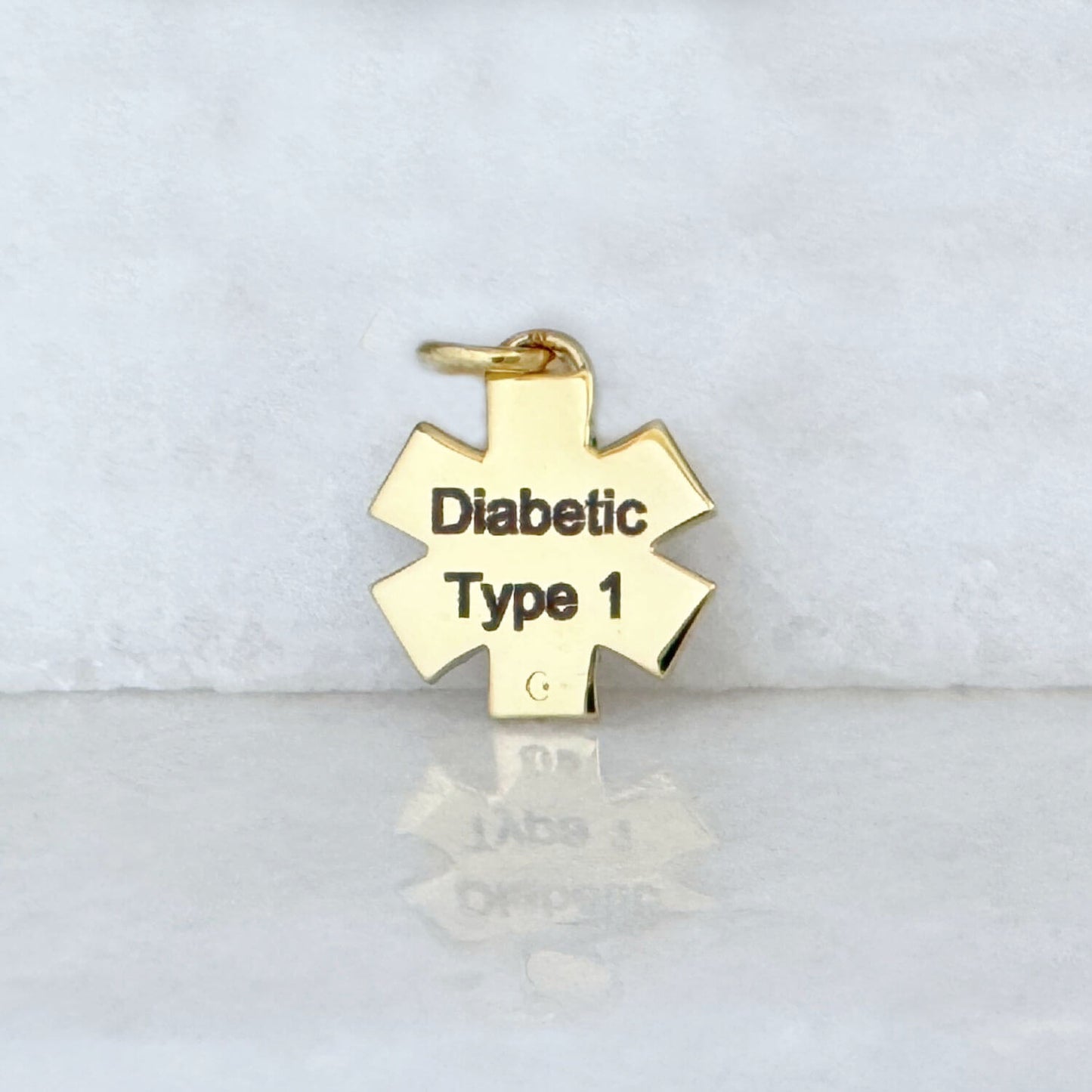 Gold medical ID star of life charm with Type 1 diabetes engraving shown on the back side