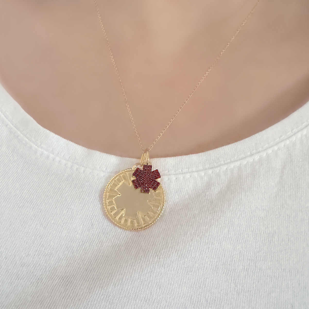 Woman Wearing Medical ID Medallion Necklace. Custom Engraved Gold Plated Medical Alert Jewelry with Garnets