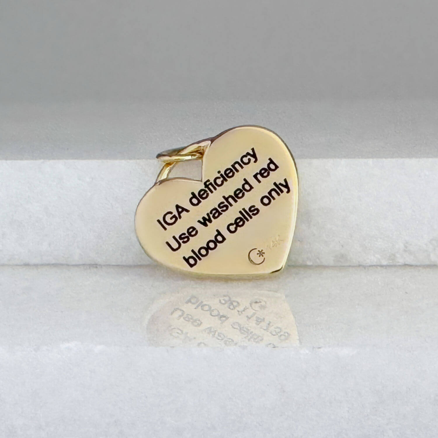 Gold Medical ID heart shaped charm jewelry with personalized engraving shown on the back side