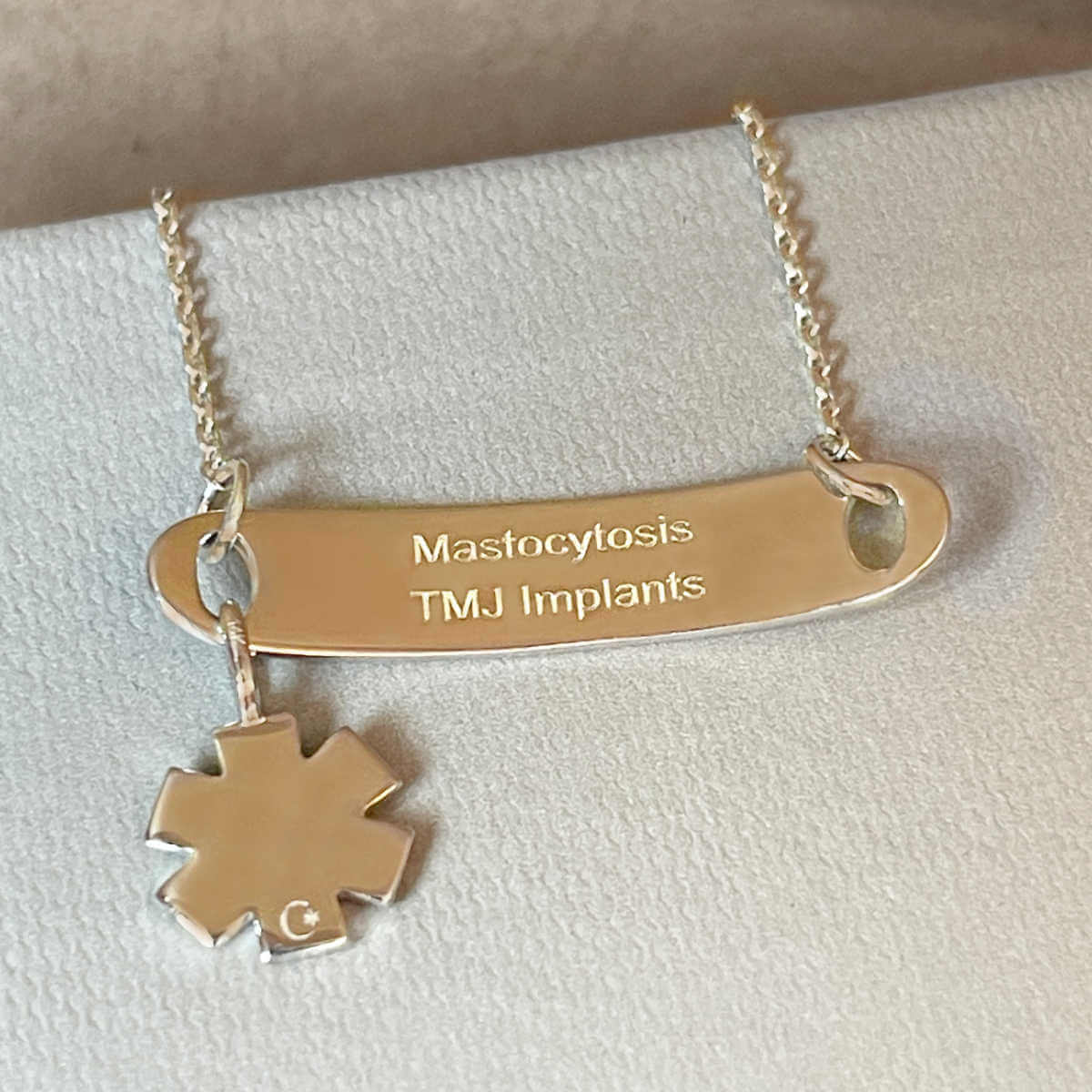 Gold medical ID tag bracelet or necklace with personalized engraving shown on the inside