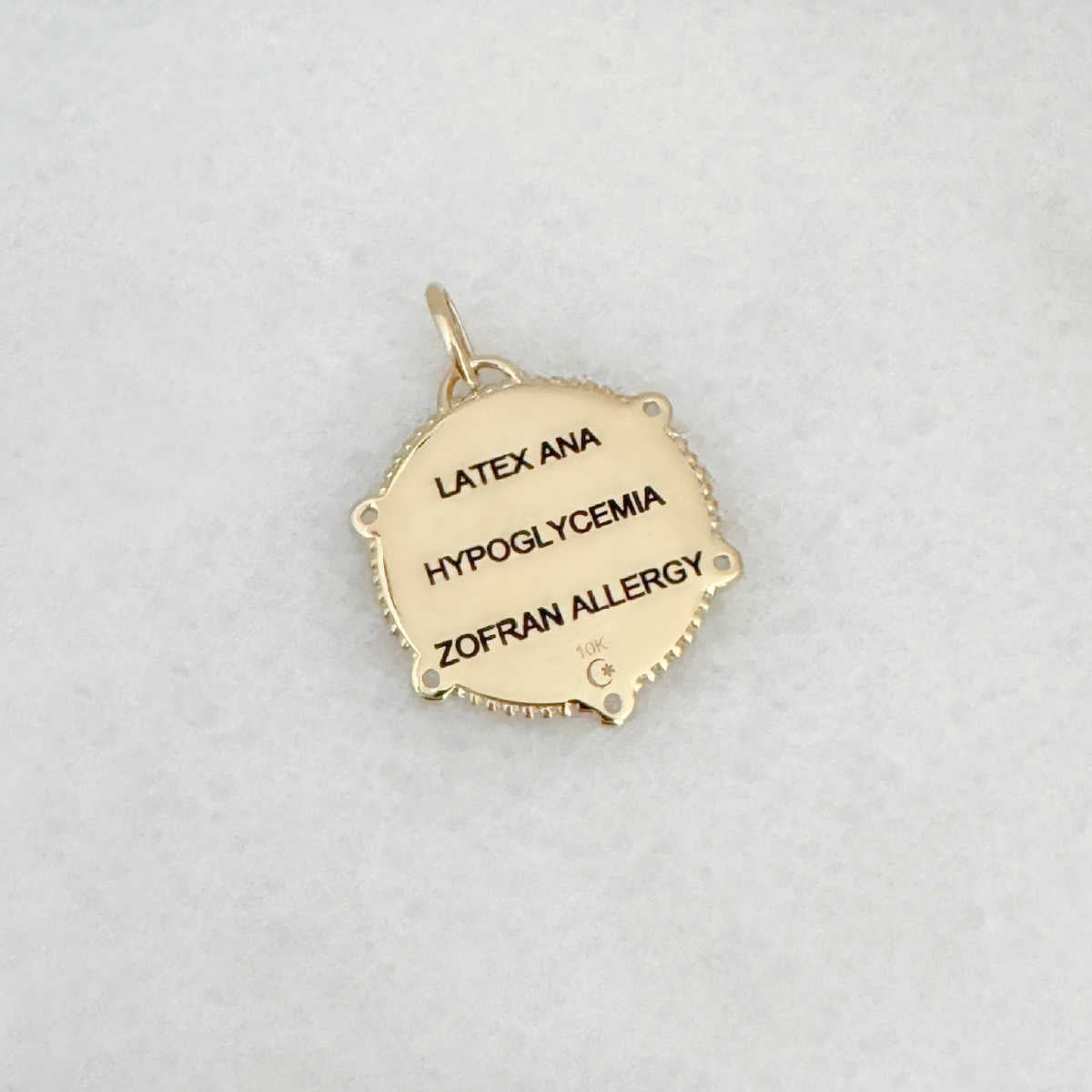 Gold Medical ID Medallion charm with personalized engraving shown on the back side