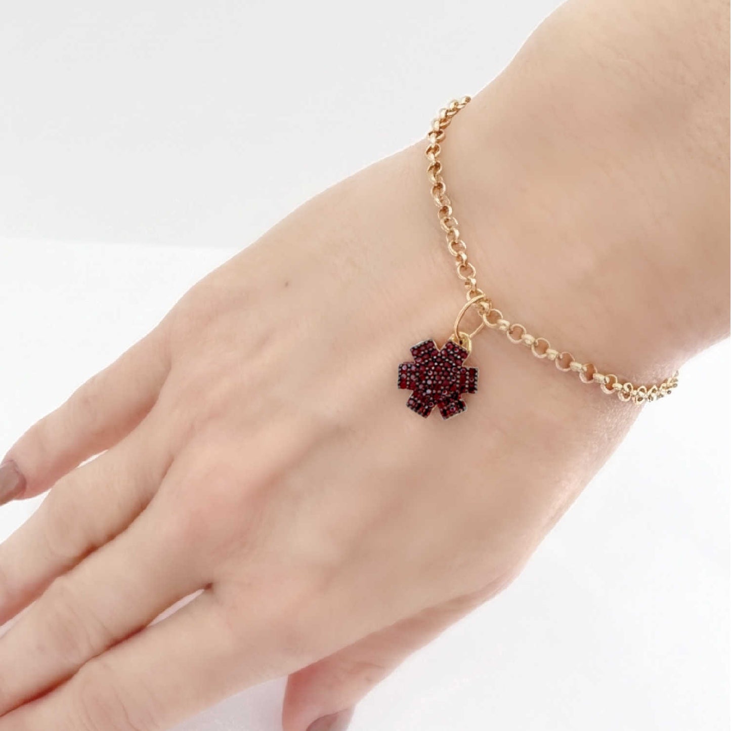 Woman wearing medical ID bracelet in gold plated sterling silver and garnet with personalized engraving