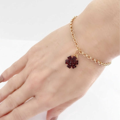 Woman wearing medical ID bracelet in gold plated sterling silver and garnet with personalized engraving