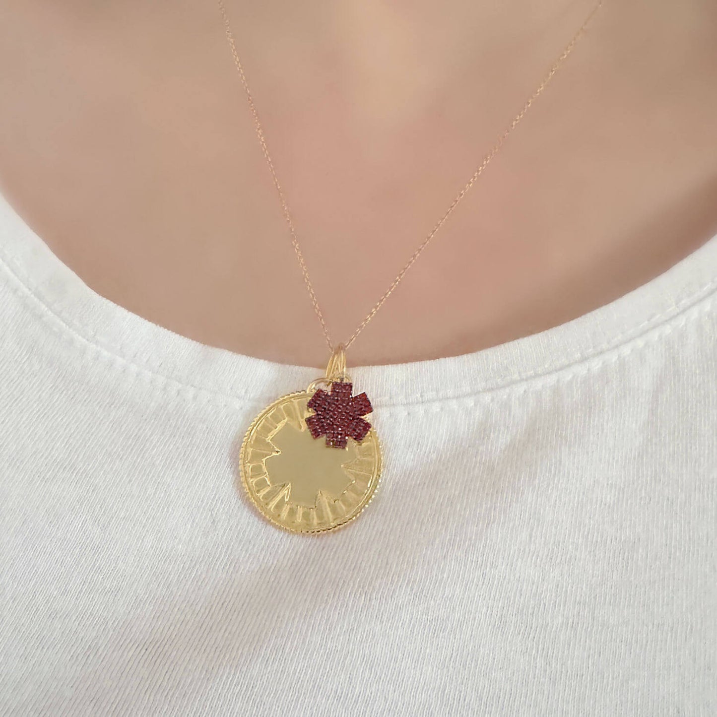 Woman wearing medical id necklace with engraved gold plated sterling silver and garnet medallion charms