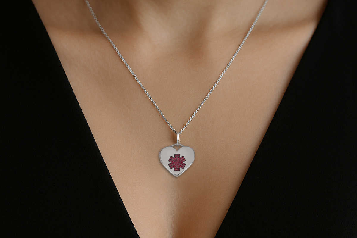 Woman wearing a heart shaped white gold & ruby medical ID pendant necklace