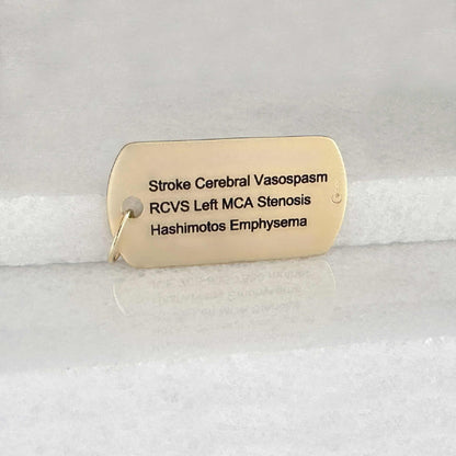 Gold medical ID dog tag with personalized engraving shown on the back side