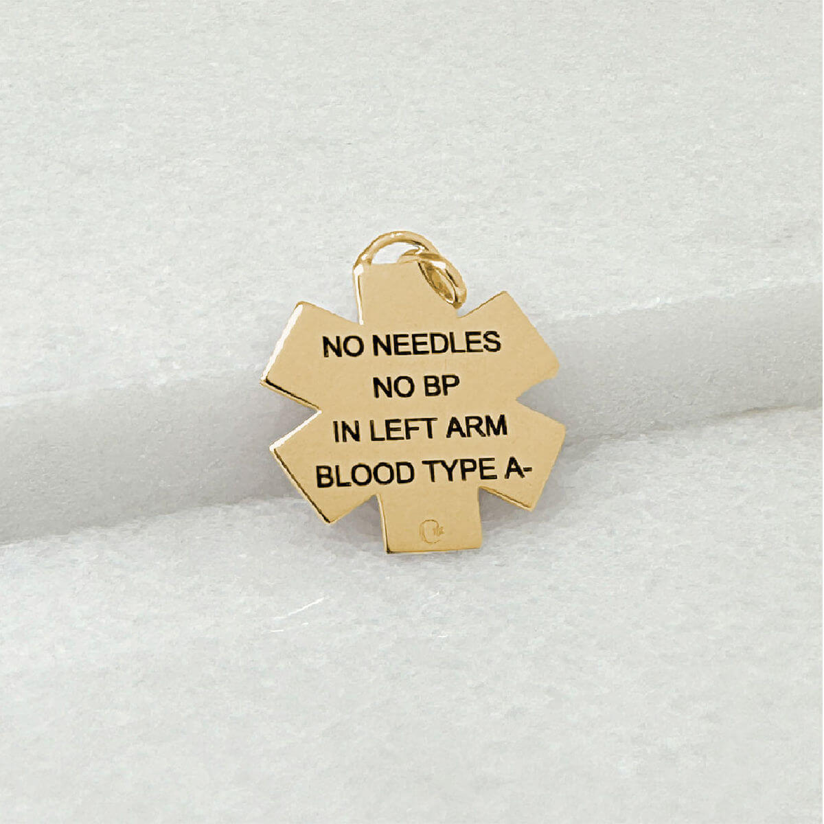 Gold Medical ID star of life jewelry with personalized engraving shown on the back side