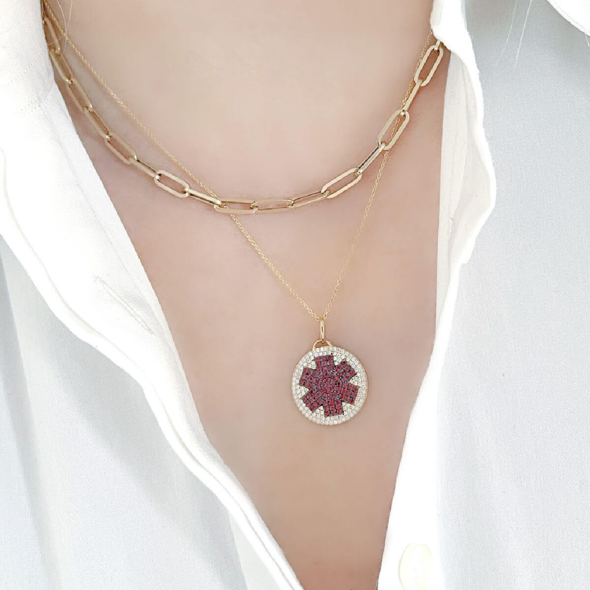 Woman wearing medical ID necklace in 14k gold with diamonds and rubies. Custom engraved medical alert pendant